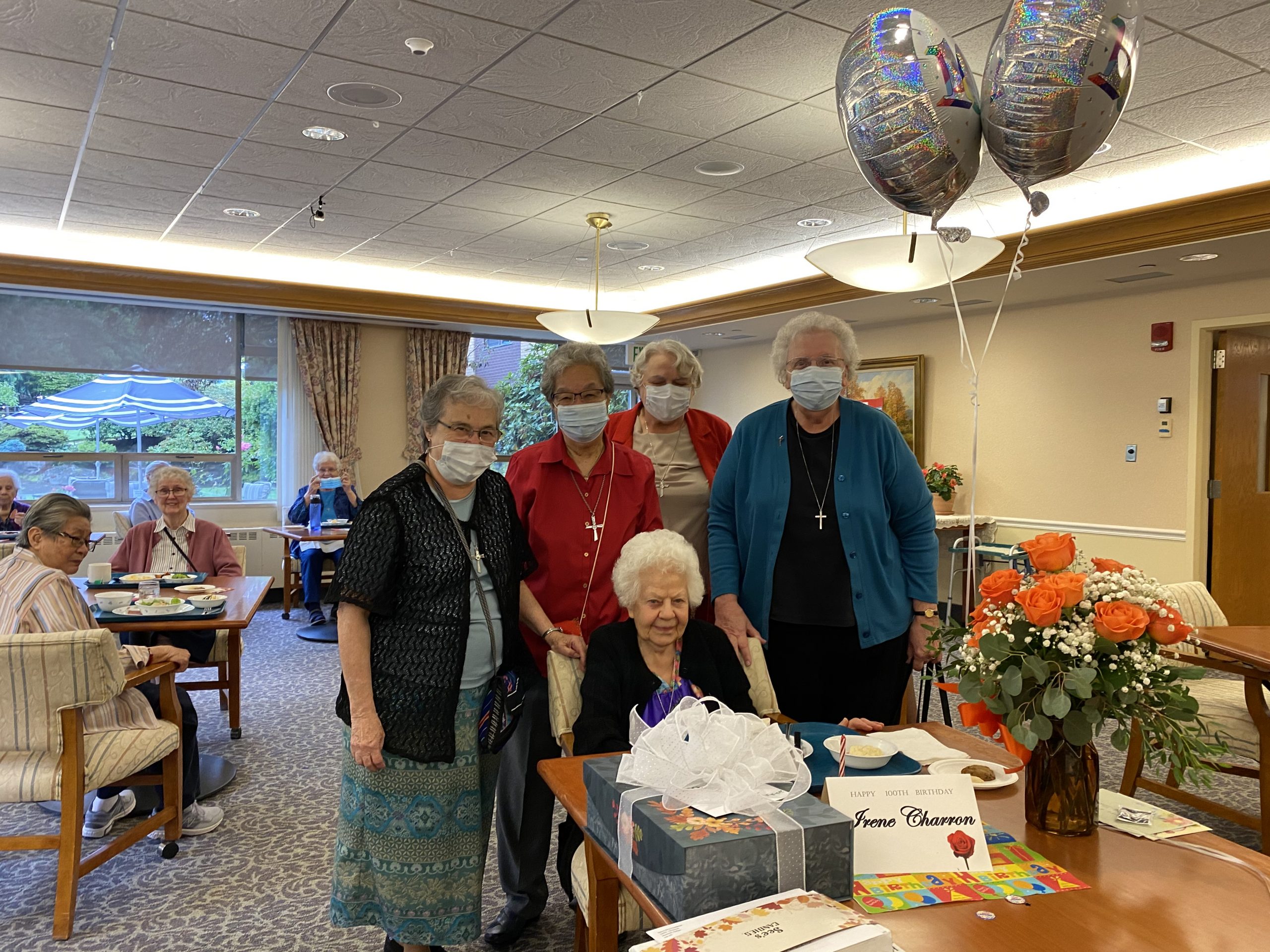 Sor Irene Charron con hermanas, tarta y regalos en su 100 cumpleaños.