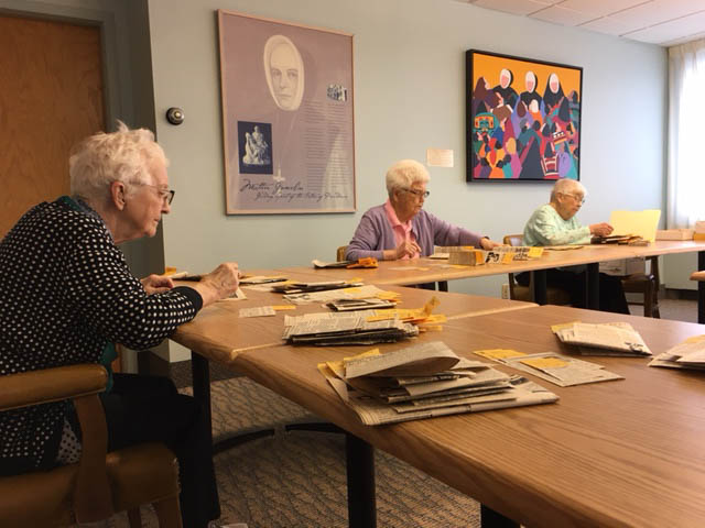 three women work at a table