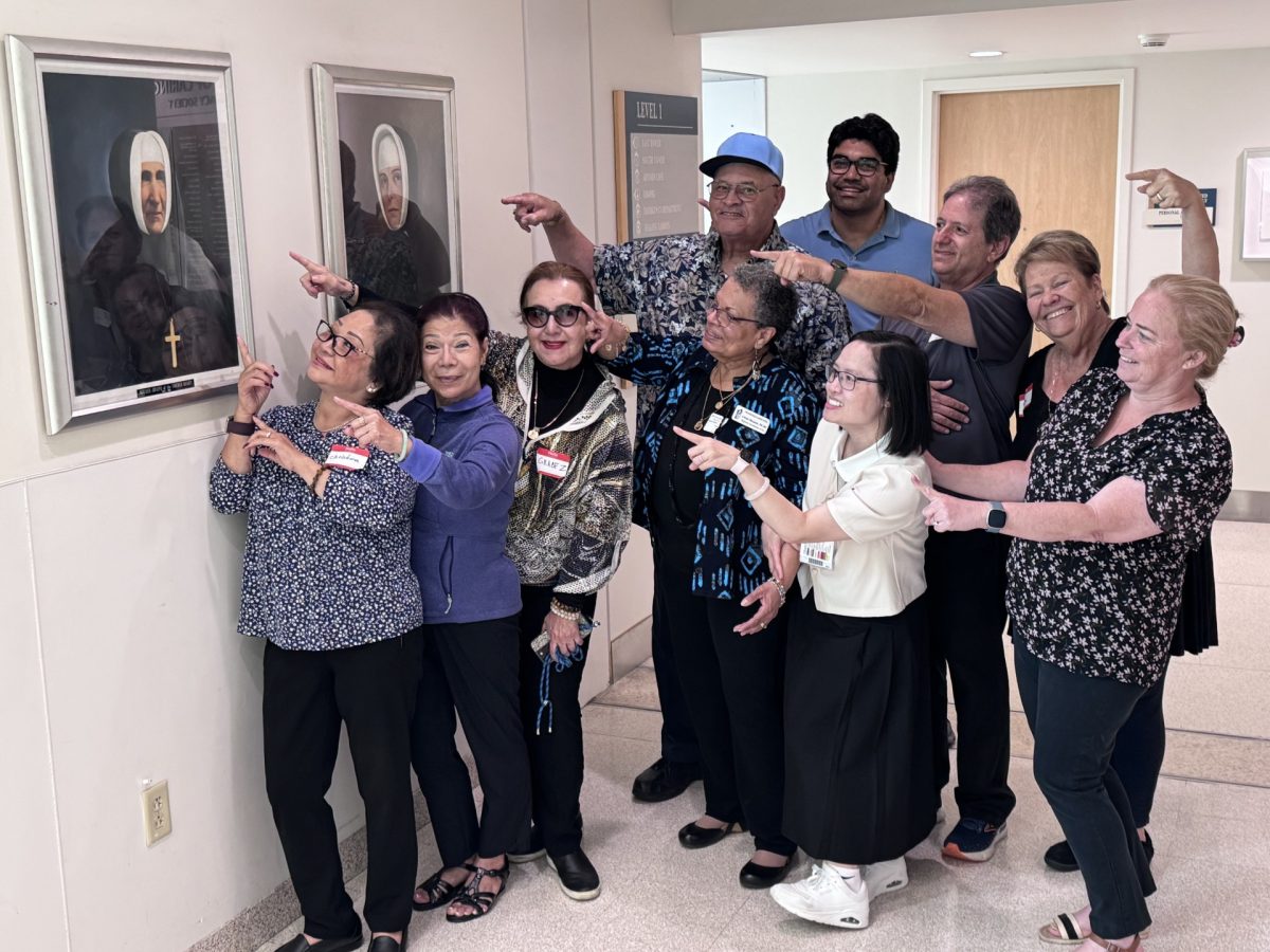 A group poses with a framed portrait of Mother Joseph of the Sacred Heart.