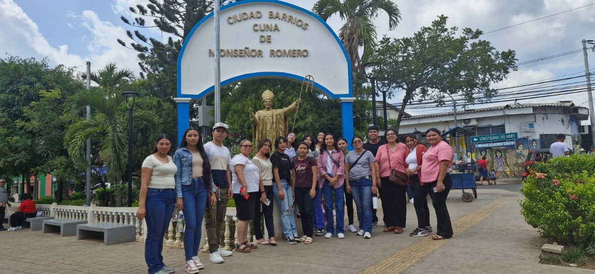 Una foto de grupo delante de una estatua dedicada a San Óscar Romero.