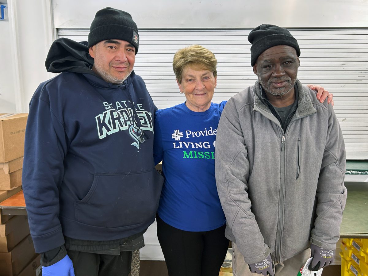 Sr. Susanne Hartung posa para una foto con dos voluntarias del refugio.