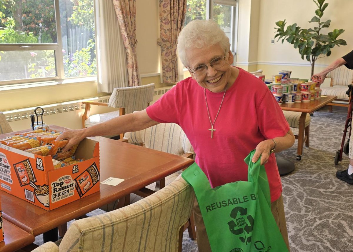 Sr. Chloe Keitges packs a grocery bag with supplies.