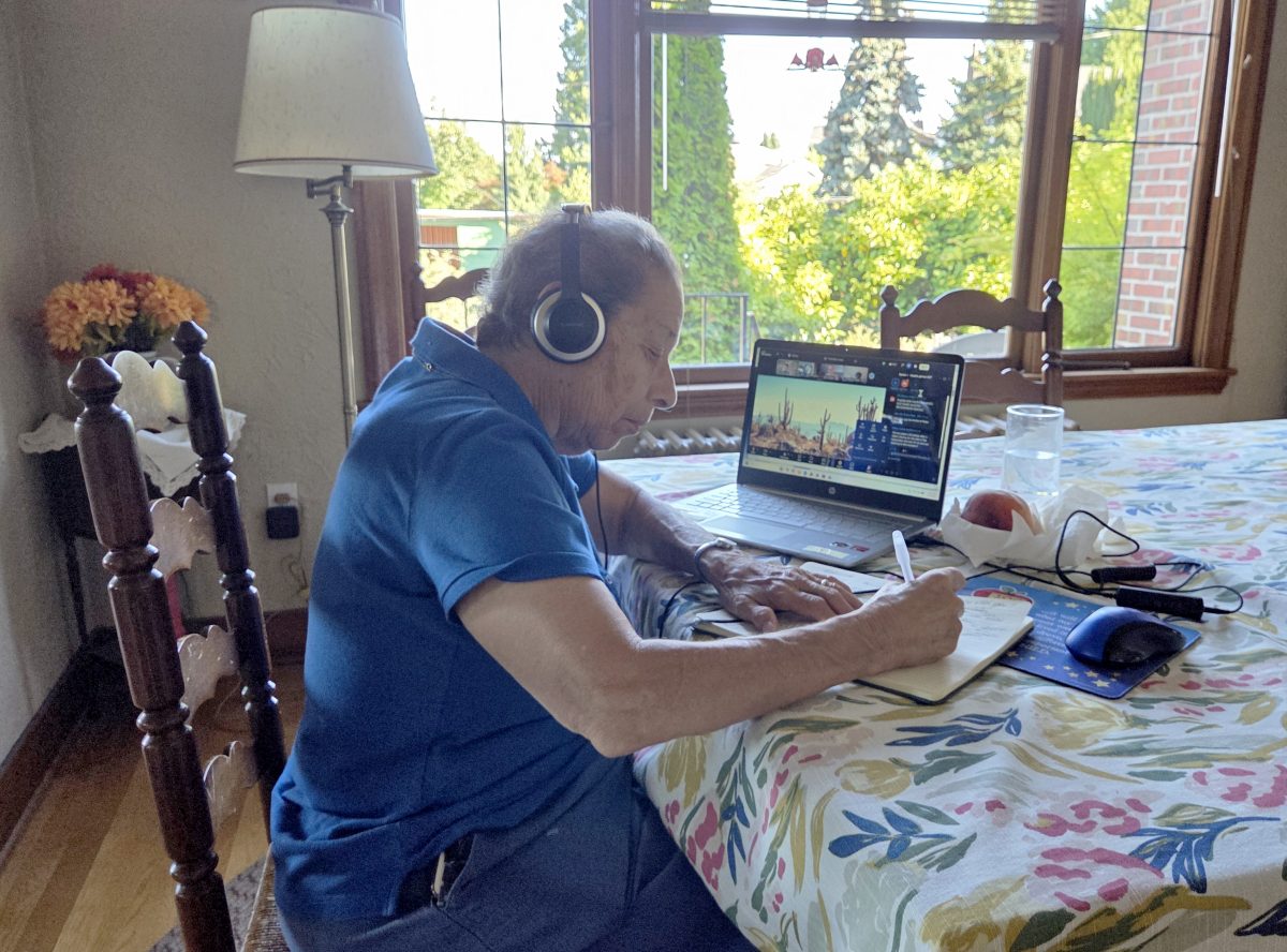 A Sister of Providence takes notes during an online meeting.