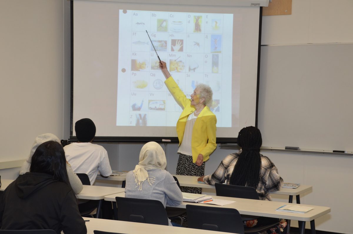Sr. Paula Cosko teaches a group of adults learning English.