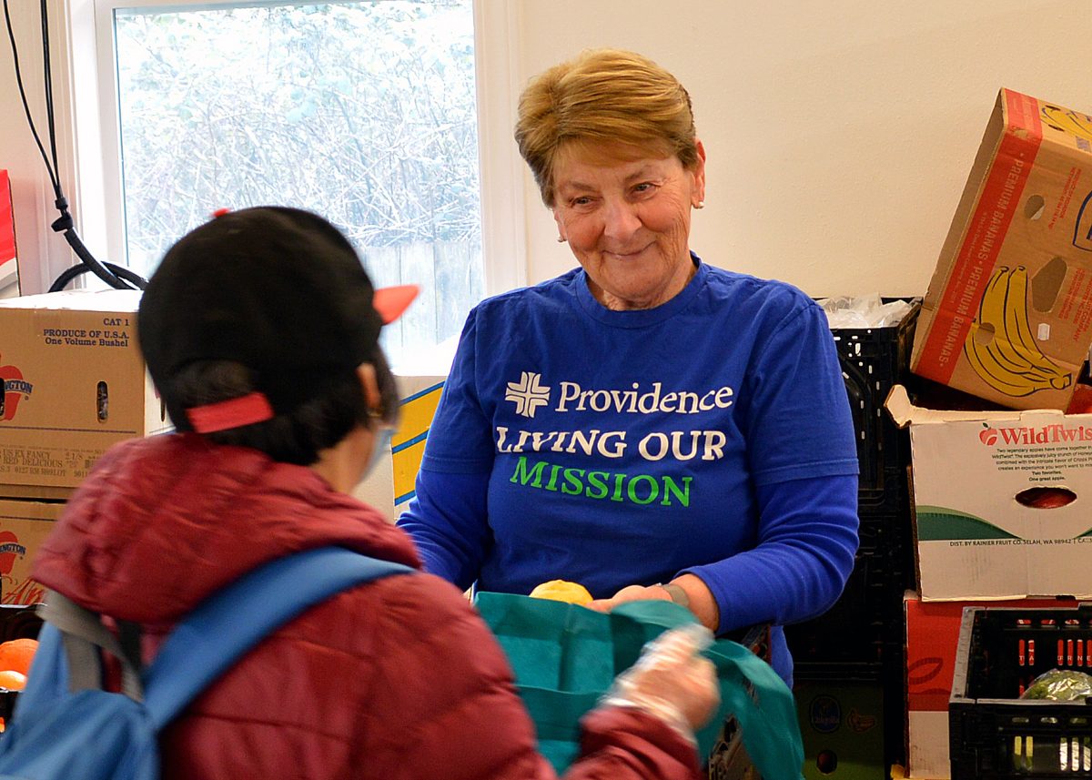 Sr. Susanne Hartung hands out fruit at a food bank.